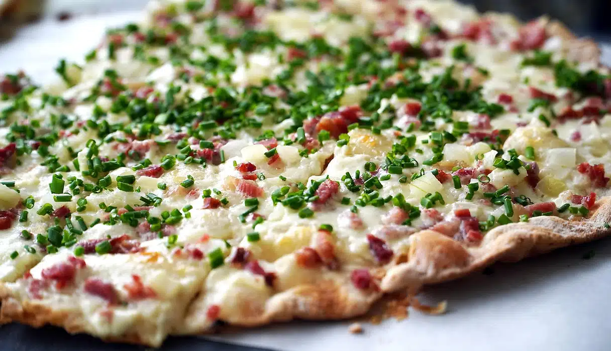 Alsace flammekueche (tarte flambée): ince hamur, krema, soğan ve lardon