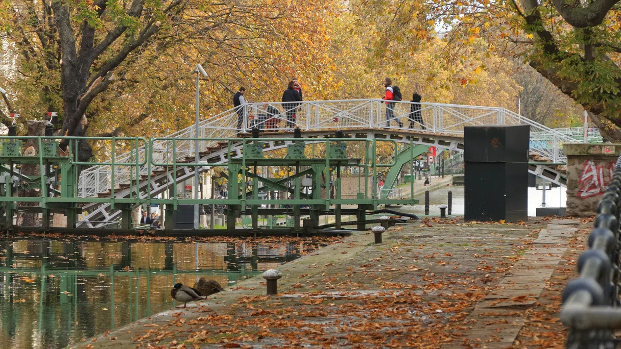 Passants traversant une passerelle sur le canal Saint-Martin à Paris