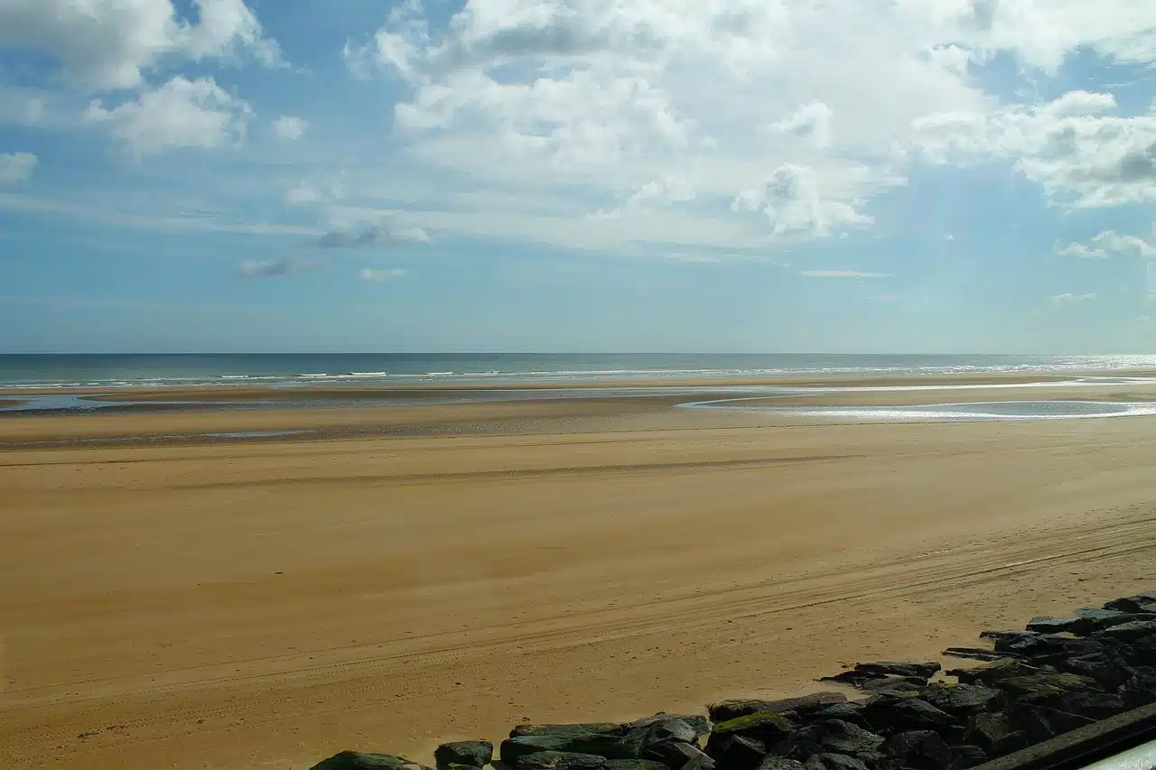 Juno Beach at low tide beneath a wide Normandy sky
