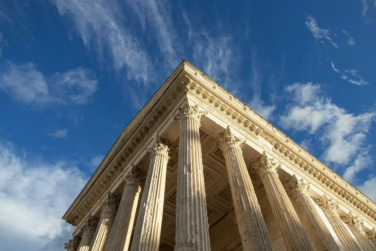 Nîmes’deki Roma tapınağı Maison Carrée’nin mavi gökyüzü önündeki Korint sütunları ve alınlığı