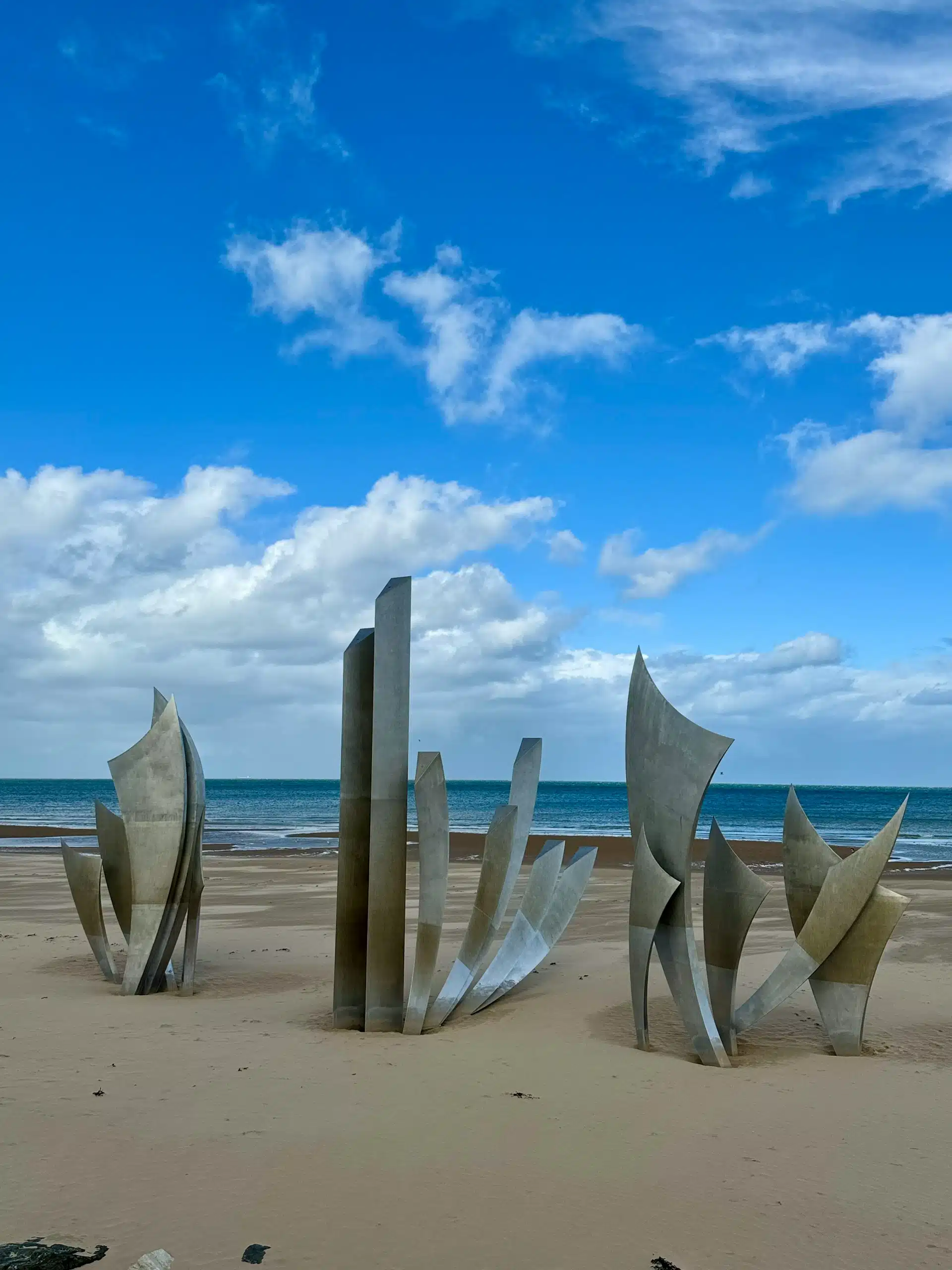 The Les Braves sculpture standing on the sands of Omaha Beach