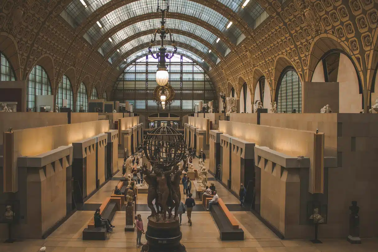 The main hall of the Musée d'Orsay in Paris, a former railway station with a vaulted glass roof and sculptures along the central aisle