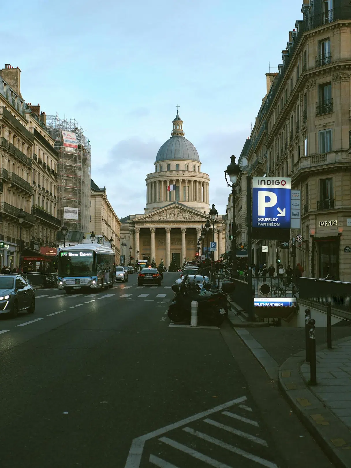 Rue parisienne avec un parking souterrain sur la gauche