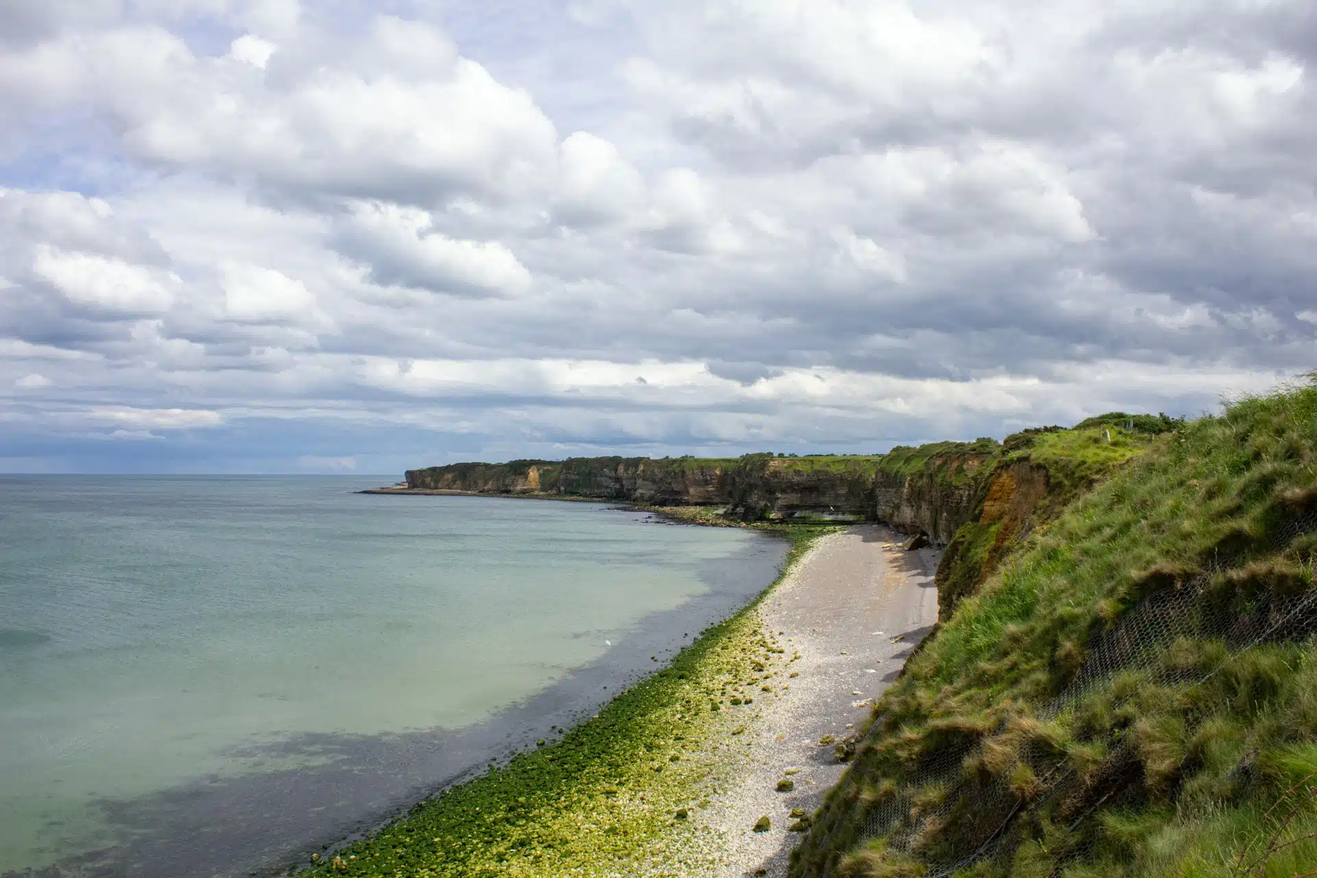 The cratered cliffs of Pointe du Hoc seen from the coastline