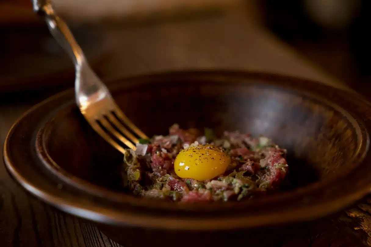 Brasserie’de steak tartare: baharatlı çiğ dana eti; yumurta sarısı, kapari, kornişon ve patates ile servis